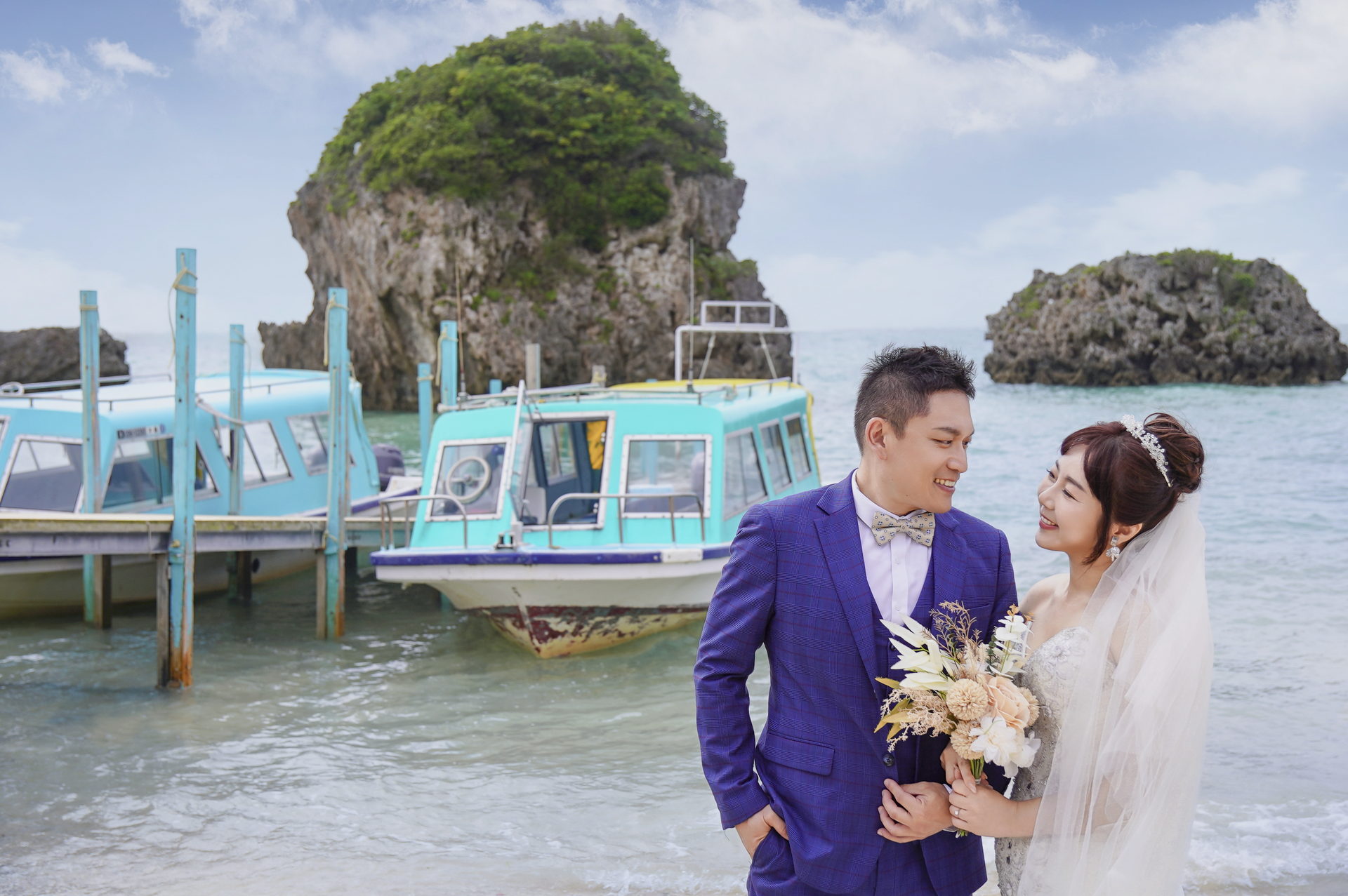 Cindy 看著 Larry，Larry 望向鏡頭，身後是碼頭與海